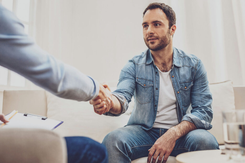A man in a one-on-one session asking his therapist about the benefits of luxury rehab