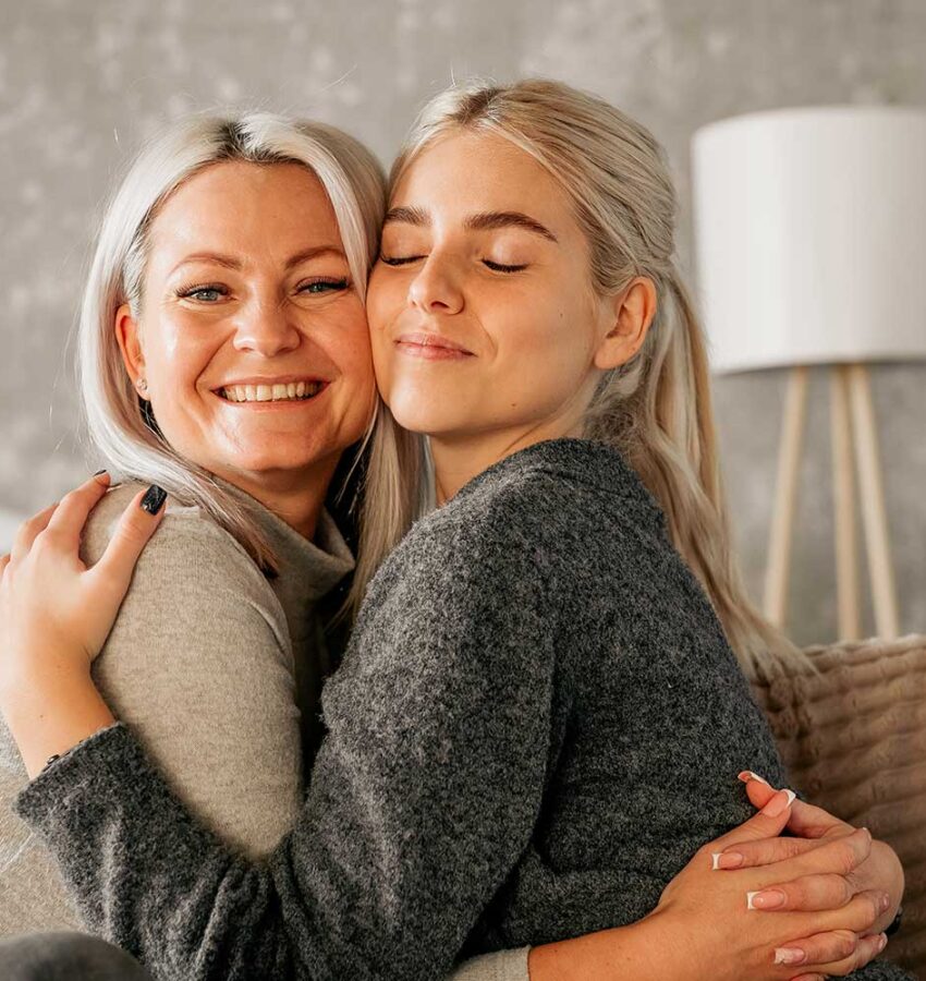 Mother hugging a Teenage Daughter At Home